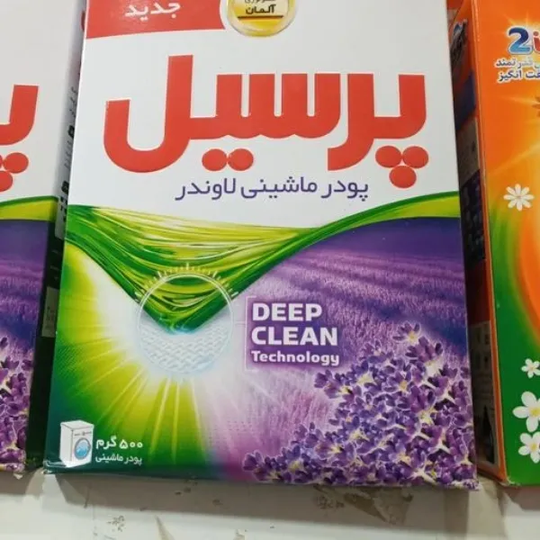 پودر ماشین لباسشویی پرسیل با فناوری تمیز کنندگی عمیق، بسته 500 گرمی، طراحی با رنگ‌های سبز و بنفش و تصویر گل‌های اسطوخودوس.