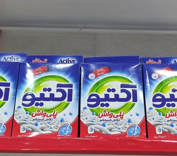 چندین بسته پودر لباسشویی ماشینی پلی واش 500 گرمی اکتیو در قفسه فروشگاه