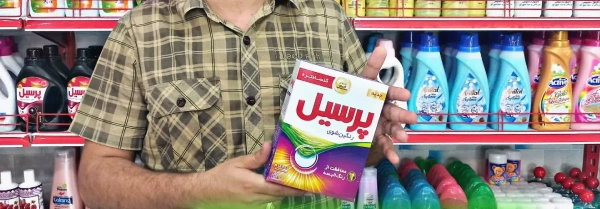 پودر لباسشویی ماشینی رنگین شوی ۶۰۰ گرمی پرسیل در دستان مشتری در فروشگاه