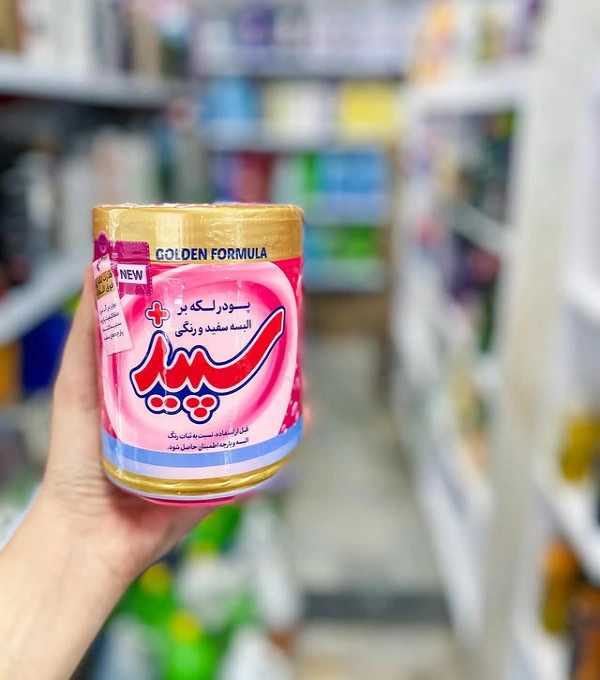 پودر لکه بر البسه سفید و رنگی 500 گرمی سپید در دست داخل فروشگاه