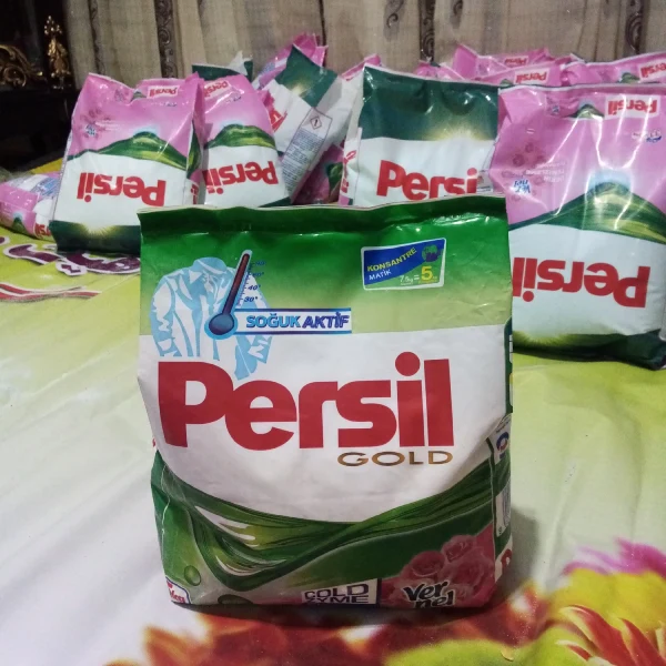 نمای نزدیک از پودر لباسشویی پرسیل گلد 5 کیلویی به همراه چند بسته در پس‌ زمینه


